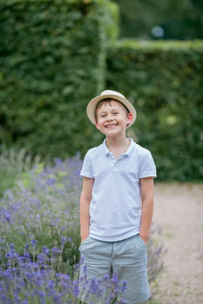 Šťastný Světlovlasý Chlapec Let Proutěném Klobouku Poblíž Kvetoucí Levandule Parku — Stock fotografie