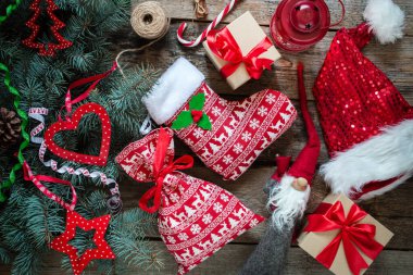 El işi kağıdında Noel hediyeleri, ahşap arka planda noel çantası, kırmızı desenli Noel ağacı, üst manzara.