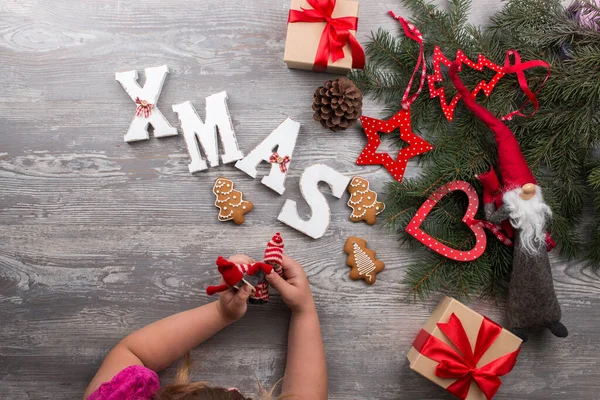 Noel tatili için bekleyen çocuk Noel karakterleriyle oynuyor, kırmızı desenli Noel ağacı, hediye kutuları, zencefilli kurabiyeler, üst manzara