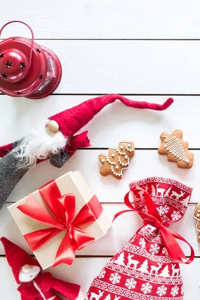 Noel hediyeleri, noel çantaları, zencefilli kurabiyeler, oyuncak Noel Baba, ahşap arka planda kırmızı lamba, dekorlu Noel ağacı, üst manzara