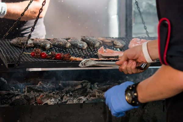 Barbekü ızgarası, bebek ahtapot ve kiraz domatesli şiş, Brezilya usulü somon bifteği, şefin gönüllü yemekleri kontrol etmesi.