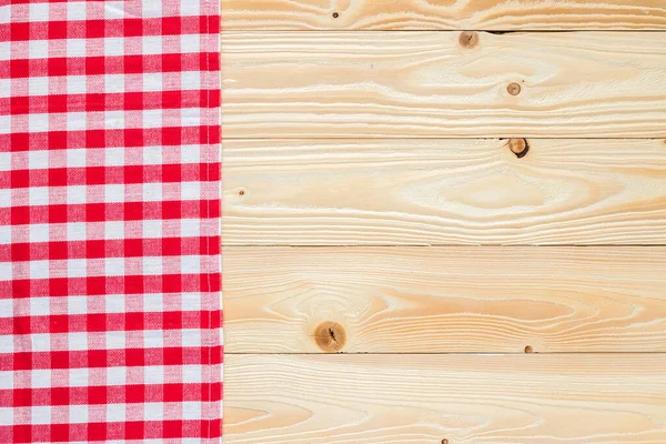 wooden table with red squared textile tablecloth, top view, horizontal