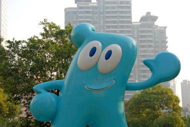 Şangay, Çin: 2010 Şangay Dünya Fuarı maskotu Haibao 'nun heykeli. Haibao açık mavi, büyük gözleri var ve el sallıyor. Dünya Fuarına hoş geldiniz..