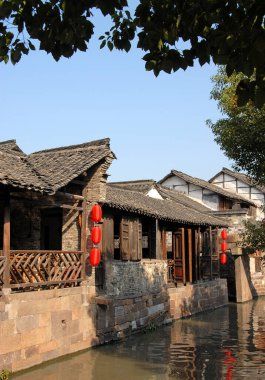 Wuzhen Su Kasabası, Zhejiang Eyaleti, Çin. Eski Çin kasabası Wuzhen 'de bir kanalın yanında kırmızı fenerler bulunan geleneksel ahşap bir bina. Wuzhen Kanal Kasabası doğunun Venedik 'i olarak da bilinir.