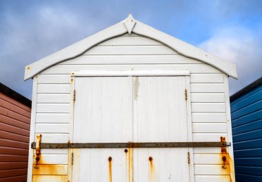 Beyaz bir sahil kulübesi. Bu eski sahil kulübesi Felixstowe, Suffolk, İngiltere 'de bir İngiliz tatil köyünde geziniyor..