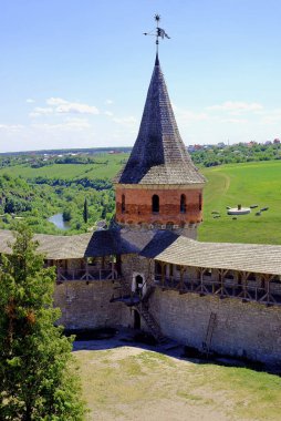 Kamyanets Podilskyi, Ukraine: Kamianets-Podilskyi Castle, the main tourist attraction of the city. View of the castle wall and tower with fields and the Smotrych River behind.