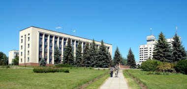 Kamyanets Podilskyi, Ukraine: Kamianets-Podilskyi City Council building located on Maydan Vidrodzhennya. People walk through the park.