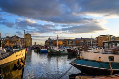 Limehouse, Londra, İngiltere: Limehouse Havzası 'nın akşam manzarası, Doğu Londra' nın rıhtım bölgesinde bir marina. Tekneler ve mavnalar rıhtımda demirli ve bir sürü modern daire var.. 
