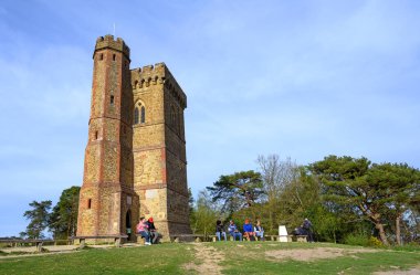 Leith Hill, Surrey, İngiltere: Leith Hill Kulesi Surrey Hills Olağanüstü Doğal Güzellik Bölgesi 'nin bir parçası olan Leith Hill' in zirvesinde. İnsanlar kulenin önünde oturuyor..