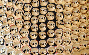 Lamba tabanındaki dairesel gamzelerin ayrıntıları. Altın metal yüzey odayı yansıtıyor. Soyut arkaplan ve doku.