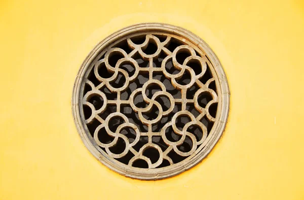 Zhenjiang, Jiangsu Eyaleti, Çin: Zhenjiang 'daki Dinghui Tapınağı' nda sarı bir duvarın içinde dairesel bir pencere..