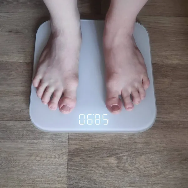 İnsan elektronik terazide yalınayak durur.
