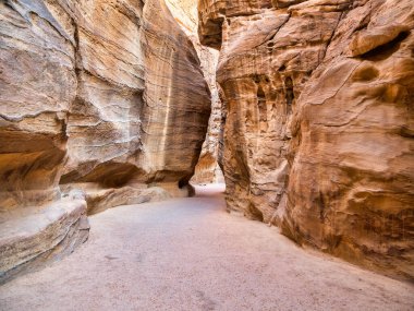 Güney Ürdün 'deki antik Nabatean şehri Petra' nın ana girişi olan kırmızı kaya duvarlarından geçen Al-Siq 'in resmi..