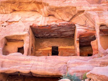 Ürdün 'ün Petra kentindeki kırmızı kum kayasına oyulmuş antik evler.