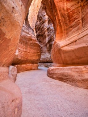 Güney Ürdün 'deki antik Nabatean şehri Petra' nın ana girişi olan kırmızı kaya duvarlarından geçen Al-Siq 'in resmi..