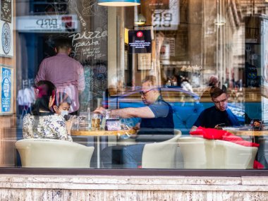 Bükreş, Romanya - 04,08,2022: Bükreş şehir merkezindeki bir lokantada turist ailesi.