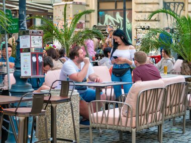 Bucharest, Romania - 04.08.2022: Tourists and locals at a outdor restaurant and cafe having a drink in the center of Bucharest