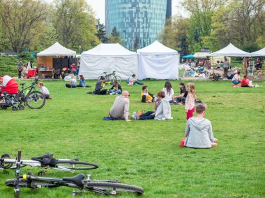 Bükreş, Romanya - 04,15,2022: Bükreş 'teki KIng MIhai I parkında (Herestrau) insanlar rahatlıyor ve çimlerde eğleniyorlar