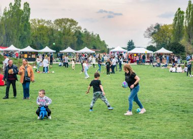 Bükreş, Romanya - 04,15,2022: Bükreş 'teki KIng MIhai I park (Herestrau) çimlerinde oynayan ve eğlenen çocuklar