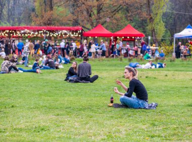 Bükreş, Romanya - 04,15,2022: Bükreş 'teki KIng MIhai I parkında (Herestrau) insanlar rahatlıyor ve çimlerde eğleniyorlar