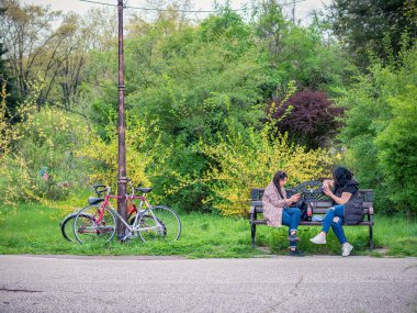 Bükreş, Romanya - 04,15,2022: Bükreş 'teki KIng MIhai I parkında (Herestrau) insanlar rahatlıyor ve çimlerde eğleniyorlar