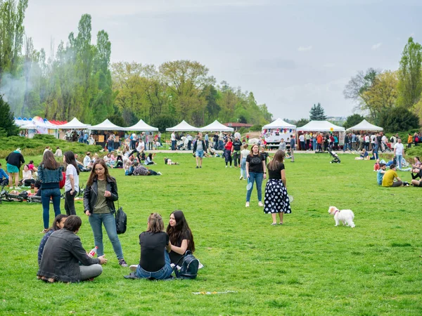 Bükreş, Romanya - 04,15,2022: Bükreş 'teki KIng MIhai I parkında (Herestrau) insanlar rahatlıyor ve çimlerde eğleniyorlar