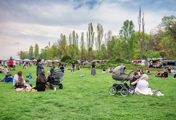 Bükreş, Romanya - 04,15,2022: Bükreş 'teki KIng MIhai I parkında (Herestrau) insanlar rahatlıyor ve çimlerde eğleniyorlar