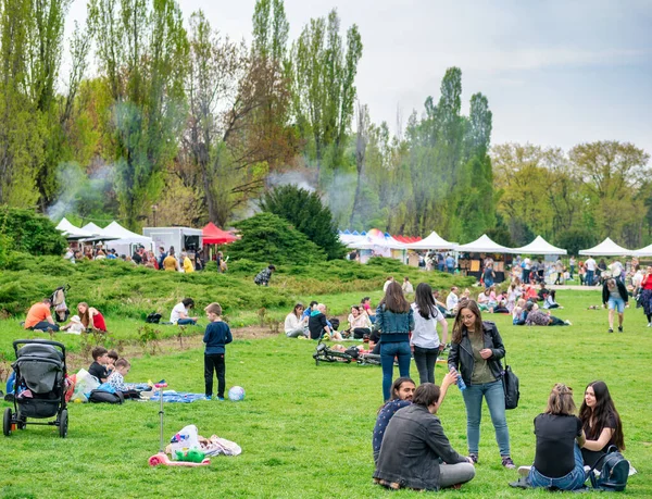 Bükreş, Romanya - 04,15,2022: Bükreş 'teki KIng MIhai I parkında (Herestrau) insanlar rahatlıyor ve çimlerde eğleniyorlar