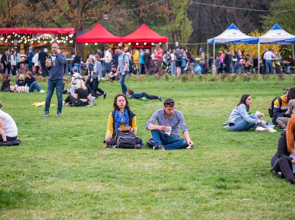 Bükreş, Romanya - 04,15,2022: Bükreş 'teki KIng MIhai I parkında (Herestrau) insanlar rahatlıyor ve çimlerde eğleniyorlar