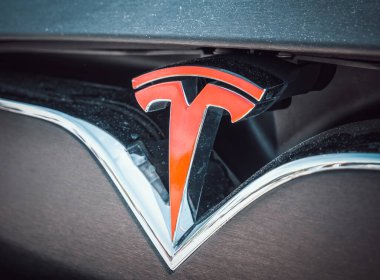 Bükreş, Romanya - 05.20.2022: Ünlü Amerikan lüks elektrikli otomobil markası Tesla 'nın logosuyla yakınlaş