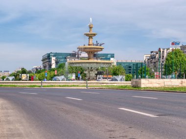 Bükreş, Romanya - Haziran 2022: Bükreş şehir merkezindeki Unirii Meydanı 'nda açık mavi gökyüzüne karşı çeşmeler ve binalar