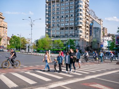 Bükreş, Romanya - Nisan 2022: Bükreş 'in merkezindeki işaretli yaya geçidi zebrası üzerinde çok sayıda insan karşıdan karşıya geçiyor