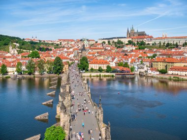 Prague, Czech Republic - June 2022: View from above with the Charles Bridge main touristic attraction with the Prague Castle in the background