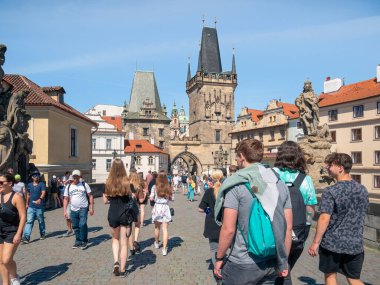 Prague, Czech Republic - June 2022: Crowds of tourist people walking and strolling on the famous Charles Bridge in Prague.