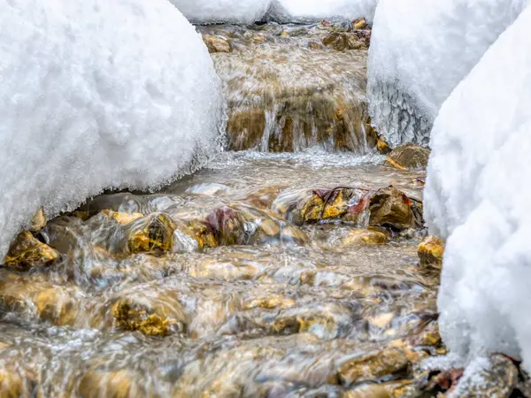 白い雪の下を流れる渓流のミニマルな抽象画 — ストック写真