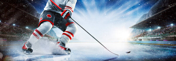 Close up of ice hockey stick on ice rink in position to hit hockey puck.
