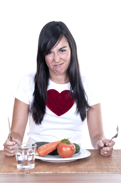 unhappy woman keeping a diet and eating vegetables