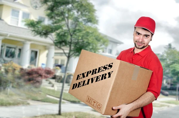 Homem de entrega em uniforme vermelho segurando a caixa — Fotografia de Stock