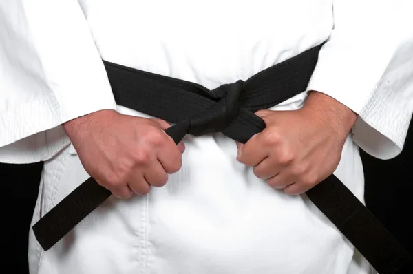 Karate-Mann bindet den Knoten an seinen schwarzen Gürtel — Stockfoto