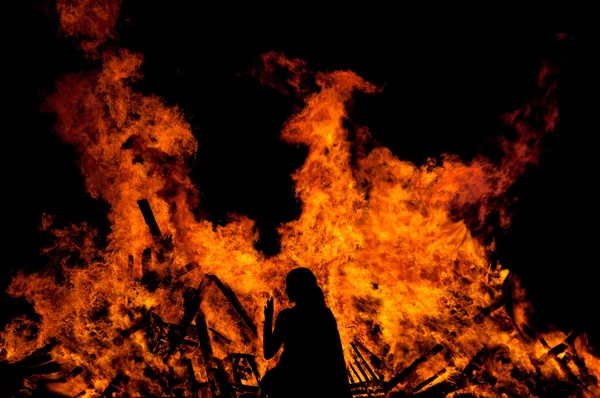 Mulher em pé na frente do fogo — Fotografia de Stock