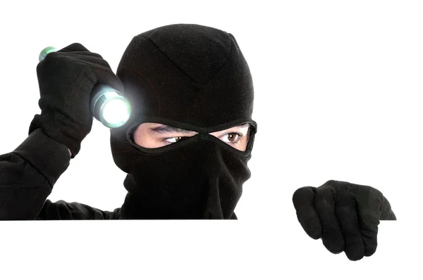 Räuber versteckt sich unter einer weißen Wand — Stockfoto