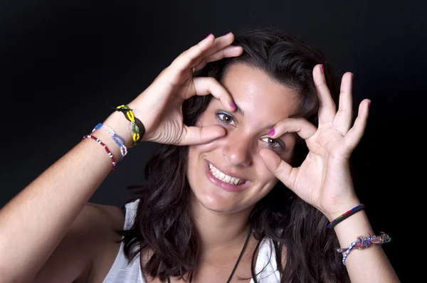 Flickan gör glasögon från fingrarna. — Stockfoto