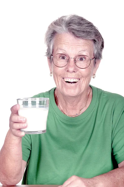 Old woman holding a glass of milk — Stock Photo, Image