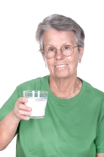 Old woman holding a glass of milk — Stock Photo, Image