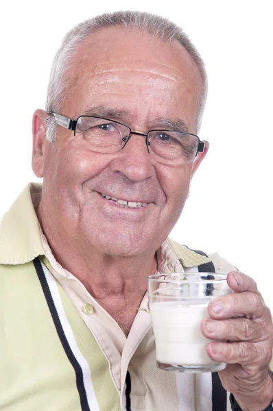 Senior holdsa glass of milk in hand — Stock fotografie