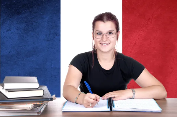 年轻的女孩学生 pc 上的背景与法国国家 fla 图库图片