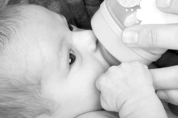 Bebé niña con un biberón . —  Fotos de Stock
