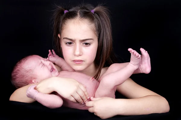 Bebé recién nacido llorando sostenido por su hermana —  Fotos de Stock