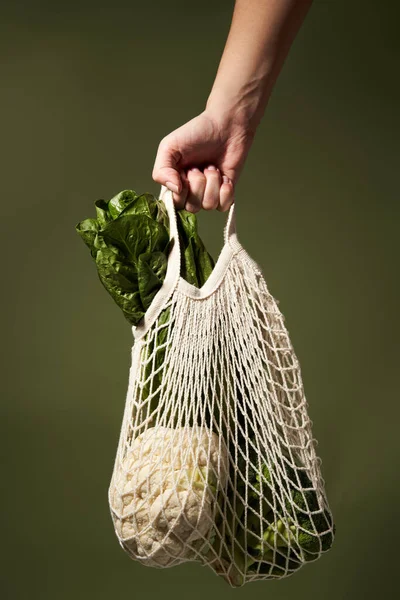 Hand med eco naturliga påsar med blomkål, broccoli, grön sallad. — Stockfoto