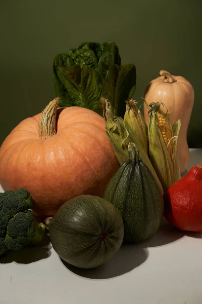 緑の壁に白いテーブルの上の季節の野菜. — ストック写真